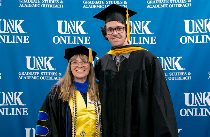 Blase Rokusek poses for a photo with UNK biology professor Kim Carlson during last week’s spring commencement ceremony. Rokusek earned a master’s degree in biology. (UNK Graduate Studies)