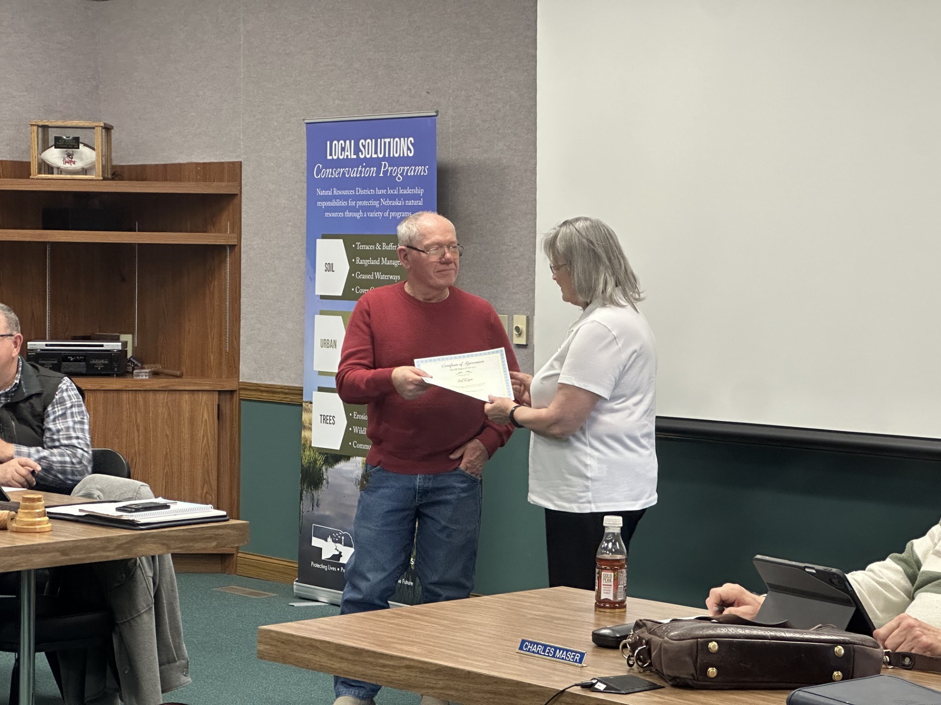 Ed Kyes receives a certificate for serving 25 years on the Board of Directors from CPNRD Chairwoman Deb VanMatre.